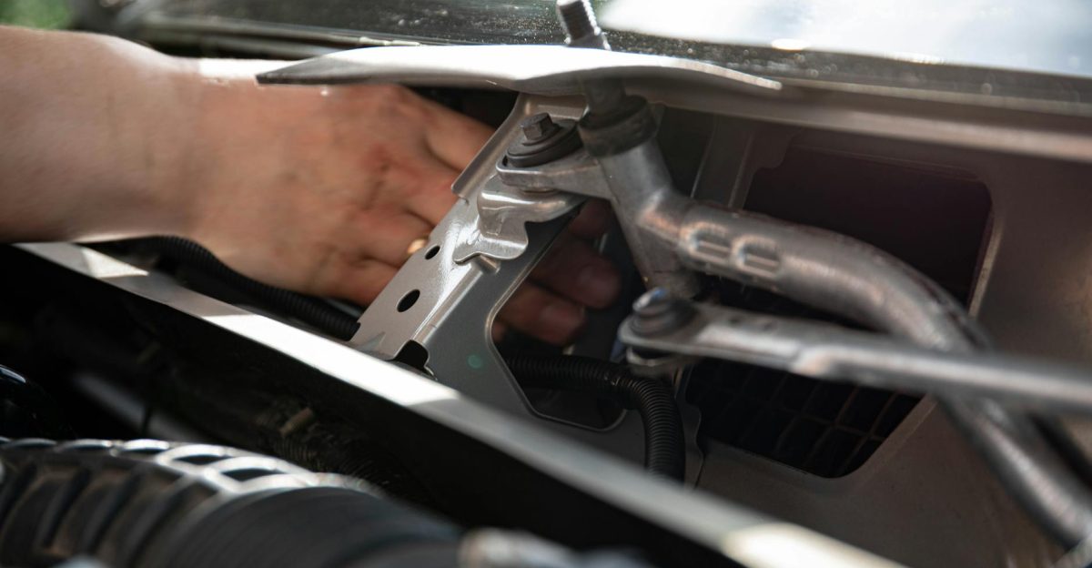 Mechanic s hand repairing car wiper mechanism in detailed close-up