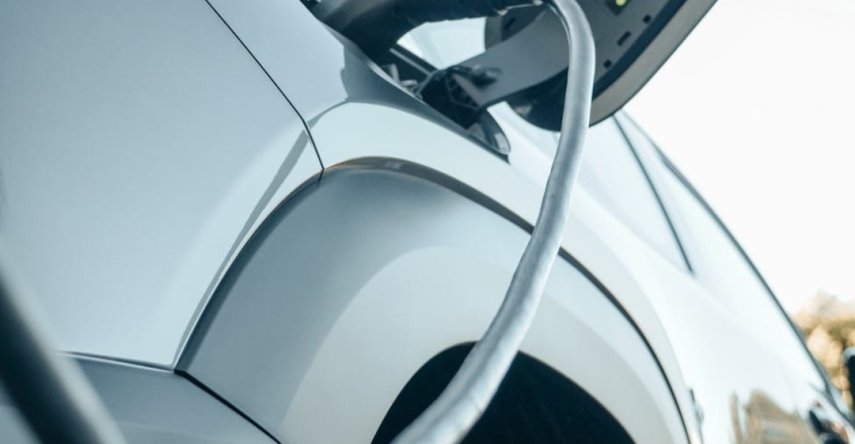 Detailed view of an electric car plugged into a charging station outdoors