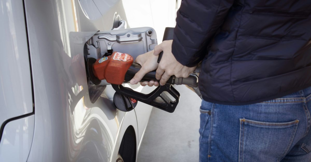 a man pumping gas into his car at a gas station