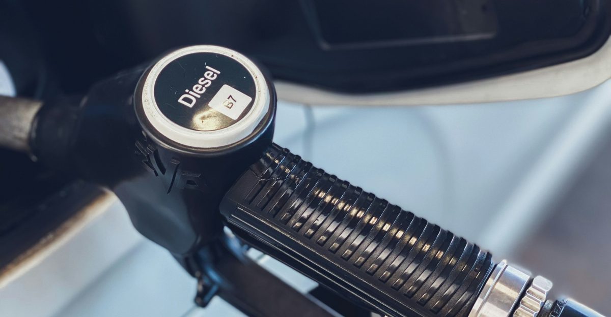 a close up of a gas pump with a car in the background