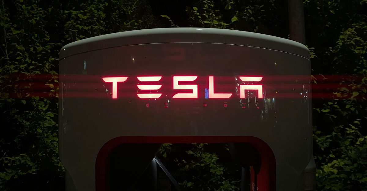 a tesla sign is lit up in the dark