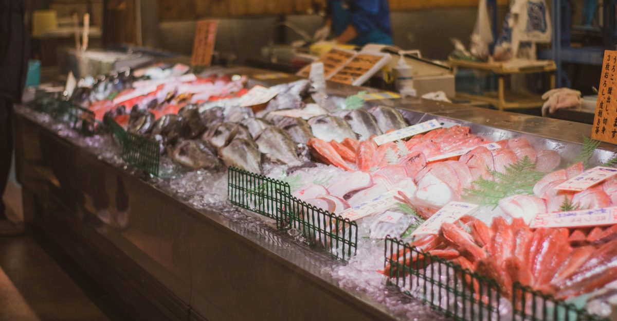 a man standing in front of a counter filled with seafood