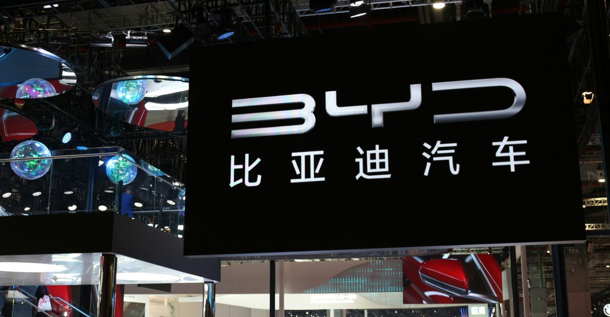 a group of people standing around a display of cars