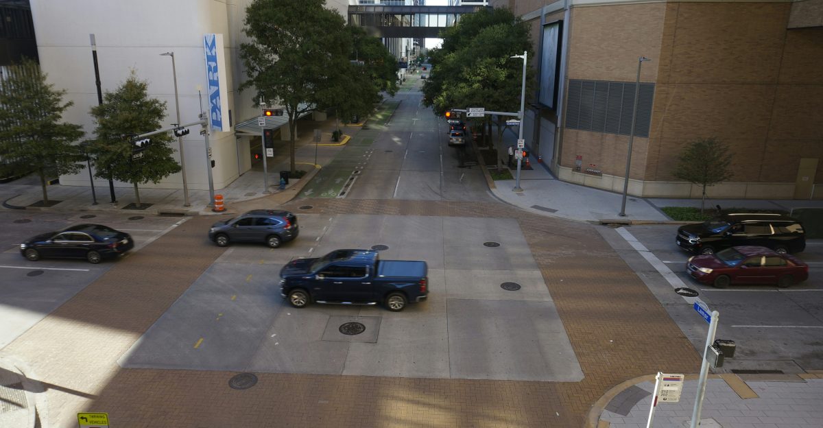 a view of a city street with cars driving down it