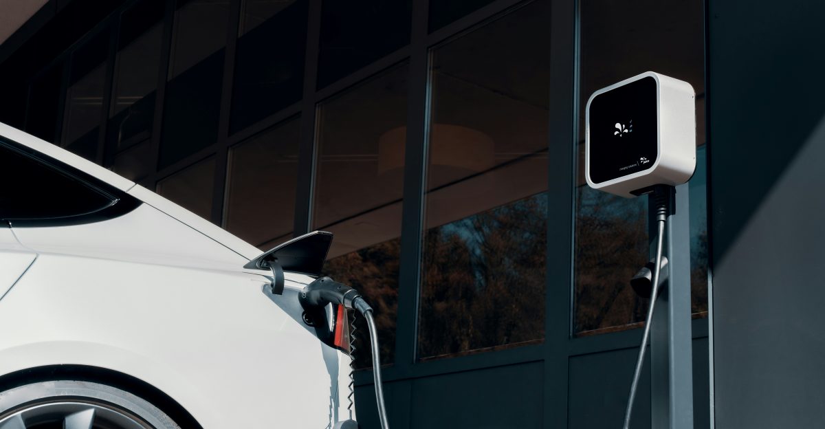 a white car plugged in to a charging station