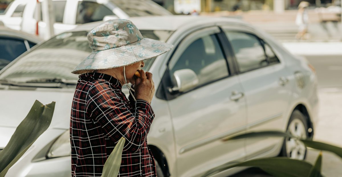 a woman talking on a cell phone next to a car