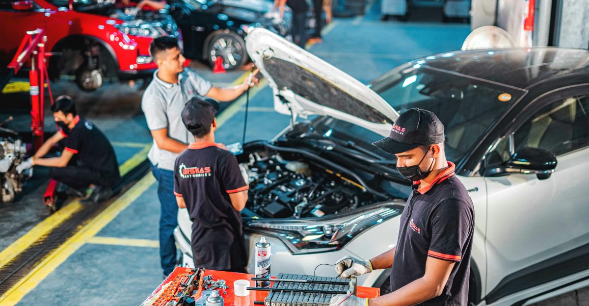 A group of men working on a car in a garage