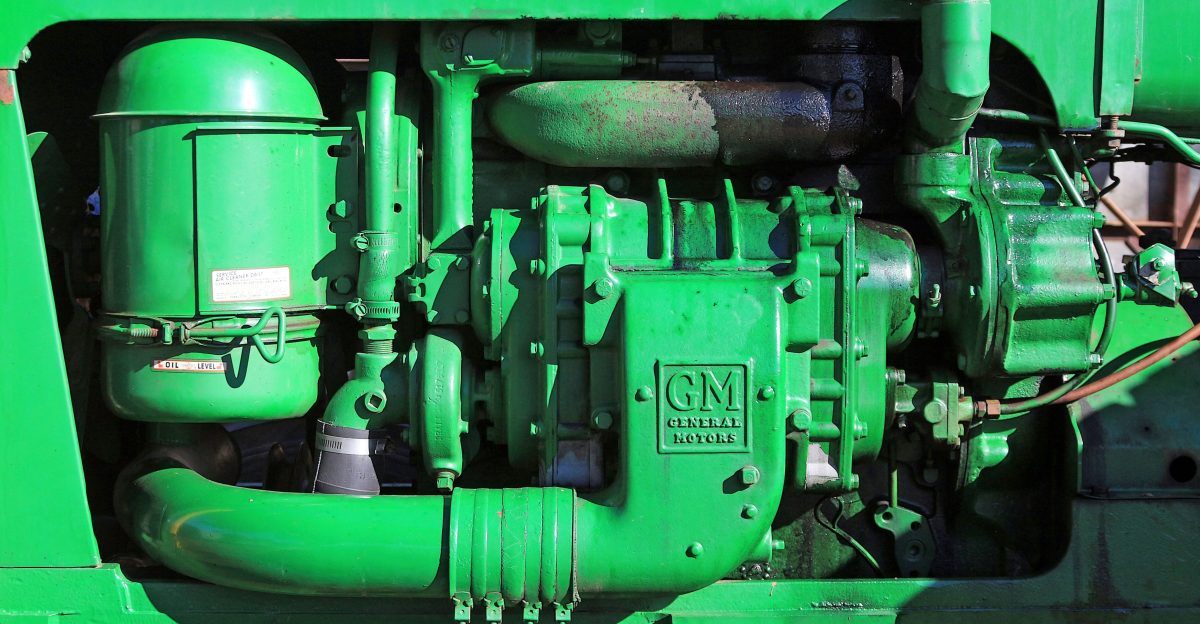 A close up of a green engine on a green truck