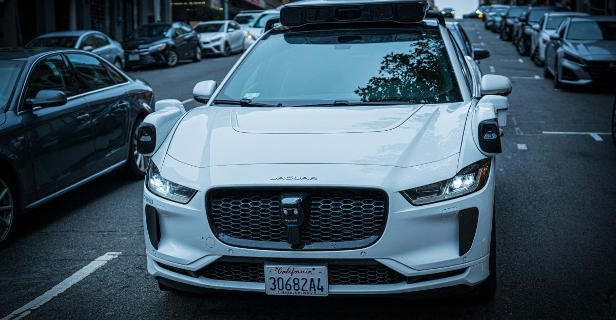 White self-driving car on a city street