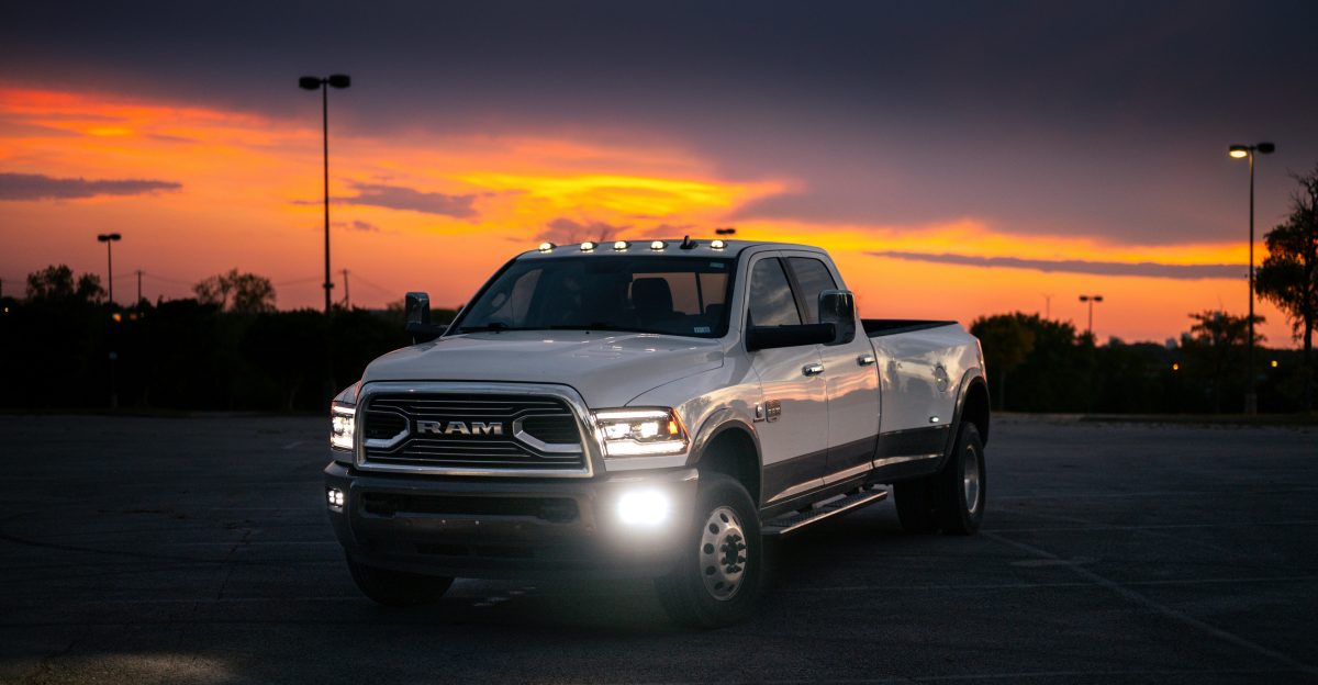 White pickup truck parked at dusk with sunset sky