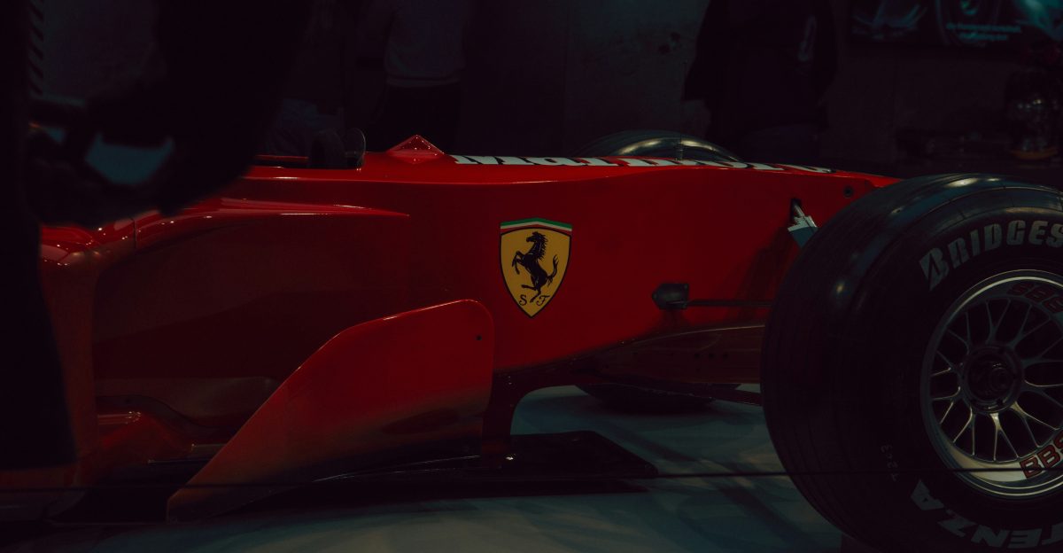 Red ferrari formula 1 car with yellow emblem