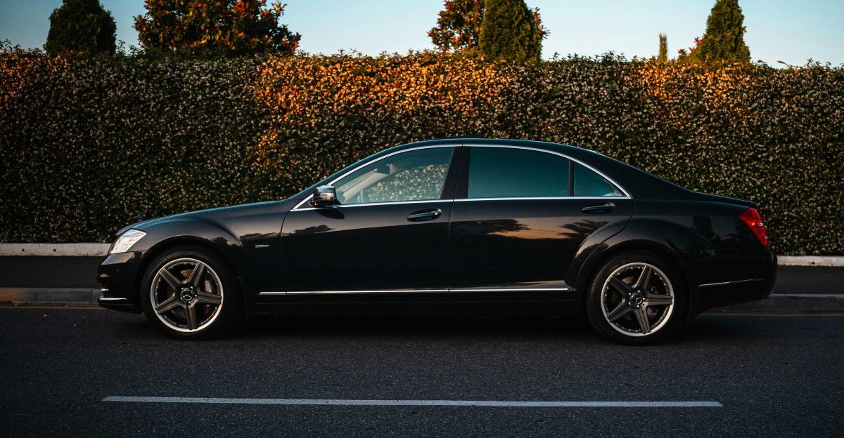 A black luxury sedan parked on the roadside
