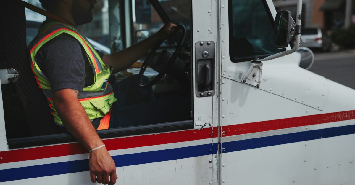 Mail carrier driving a white truck